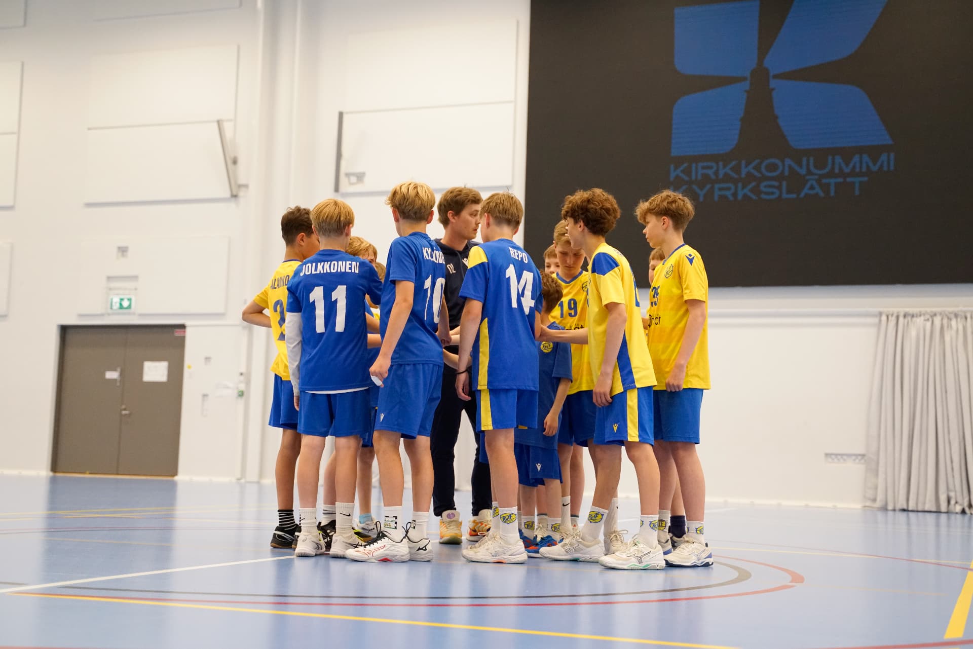 Tränaren samlar KyIF-laget i ring i Kyrkslätts idrottshall