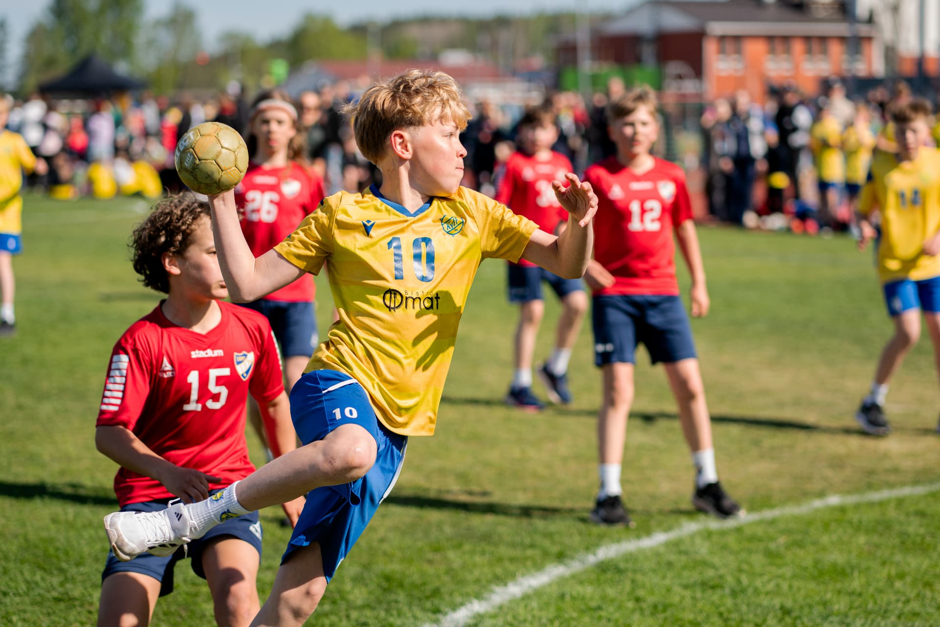 KyIF-spelare i gul tröja hoppar och skjuter under Sjundeå Cup